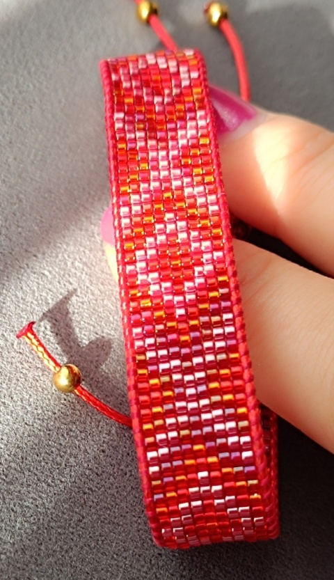 Czerwona bransoletka tkana z koralików w graficzny wzór w stylu boho