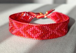 Czerwona bransoletka tkana z koralików w graficzny wzór w stylu boho